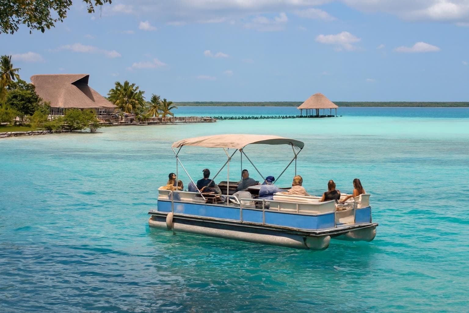 Shaded pontoon boat cruising on Bacalar Lagoon with turquoise waters and passengers onboard